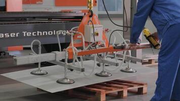 Worker uses suction cups for transporting large sheets of metal video