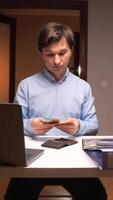 vertical Office worker counting banknotes at desk with laptop and wallet video