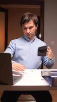 vertical Office worker shaking empty wallet at desk with laptop video