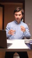 vertical Office worker taking medicine at work with laptop and files video