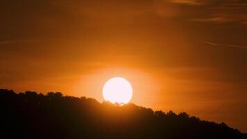 The sun is setting over a hill with trees video