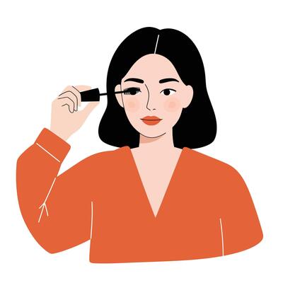 Woman applying mascara with a focused expression while preparing for makeup routine