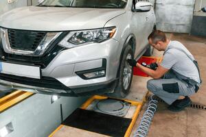 Adjusting ,the tire. Man is works in ,the automobile repairing salon photo