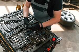 Standing by, the toolbox. Man is works in the automobile repairing salon photo