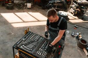 Top, view of ,employee that standing by the toolbox. Man is works in the automobile repairing salon photo