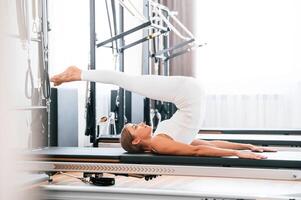 Legs, are, up. Young woman in fitness center is doing exercises photo