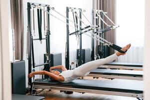 Slim body type. Young woman in fitness center is doing exercises photo