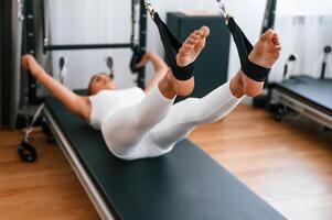 Young woman, in fitness center, is doing exercises photo