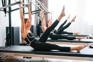 Doing, abs ,exercises by lifting the legs. Women in fitness center photo