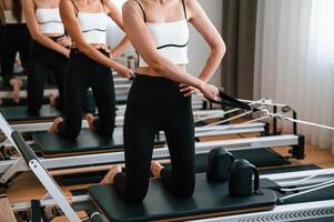 Against the, mirror. Women in fitness center are doing exercises photo