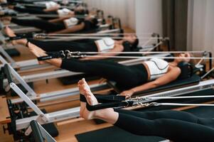 Side view. ..Stretching the legs. Women in fitness center are doing exercises photo