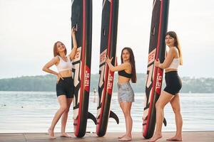 Women ,are, standing with sup boards against the lake photo