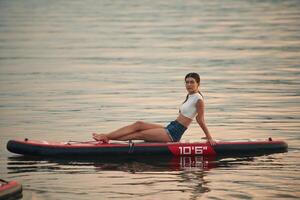 Young, woman is on sup boards in the lake photo