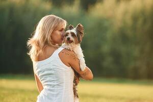 Rear view., Beautifu,l woman is with her cute dog outdoors on the field photo