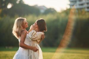 Side ,view, conception, of love and care. Woman with her daughter is on the summer field photo