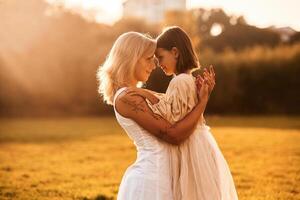 Embracing each other. Woman ,with, her daughter is on the summer field photo