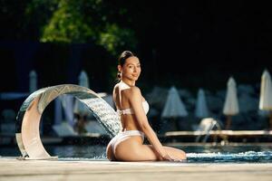 Conception of resort and relax. Woman in white underwear is in the pool photo