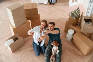 Top view. Young couple with dog are moving to new home photo