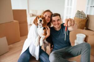 Holding keys for new appartment.... Young couple with dog are moving to new home photo