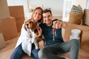 Man with keys. Young couple with dog are moving to new home photo
