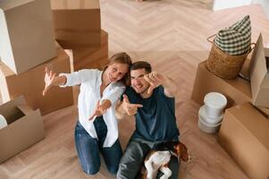 Top, view. Young couple, with dog are moving to new home photo
