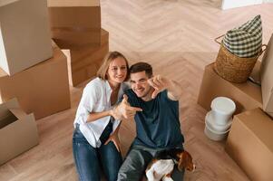 Top view., Young couple with dog are moving to new home photo