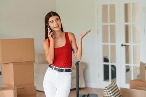 With, smartphone. Young woman in casual clothes is moving to new house photo