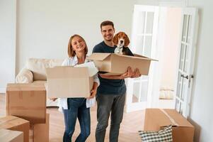 Dog is in the box. Young couple are moving to new home photo