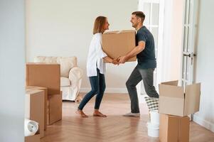 With one, heavy box. Young couple moving to new home photo