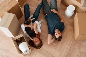 View from, the top, lying down and resting. Young couple with dog are moving to new home photo