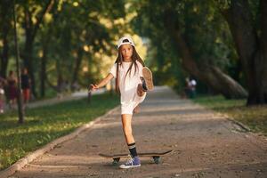 On the road ,in park.. Happy little girl with skateboard outdoors photo