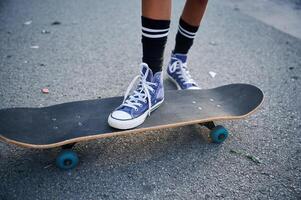 Close up, view of skateboard riding by a young girl photo