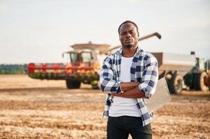 Standing with arms crossed,. Beautiful African American man is in the agricultural field photo