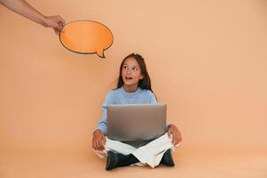 Hand is holding sticker with copy space for text, thoughts. Sitting with laptop. Cute young girl photo