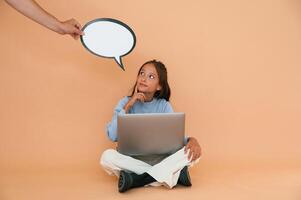 Hand is, holding ,sticker with copy space for text, thoughts. Sitting with laptop. Cute young girl photo