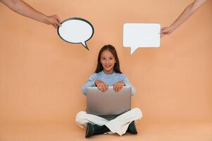 Thoughts stickers above. Sitting with, laptop. Cute young girl is in the studio against background photo