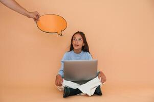 Hand, is ,holding sticker with copy space for text, thoughts. Sitting with laptop. Cute young girl photo
