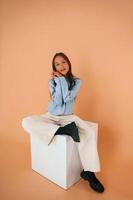 Cute young girl is in the studio against background photo