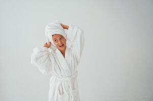Having f,un. With towel, on head. Conception of beauty and self care. Young girl is in the studio photo