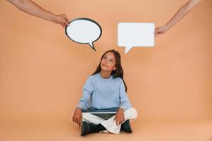 Thoughts ,stickers, above. Sitting with laptop. Cute young girl is in the studio against background photo