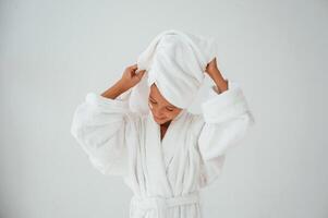 With towel, on the head. Conception of beauty and self care. Young girl is in the studio photo