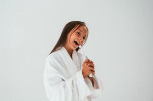 Using ,the toothbrush.. Conception of beauty and self care. Young girl is in the studio photo
