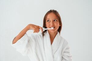 Using the toothbrush. ,Conception, of beauty and self care. Young girl is in the studio photo
