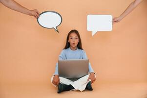 Thoughts ,stickers above. Sitting with laptop. Cute young girl is in the studio against background photo