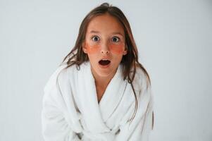 Positive and surprised facial expression.. With eye patches. Conception of beauty. Young girl is in the studio photo