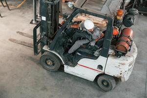 View from ,the, top, in the forklift. Young factory worker in grey uniform photo