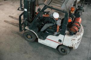 View from the top,, in the, forklift. Young factory worker in grey uniform photo