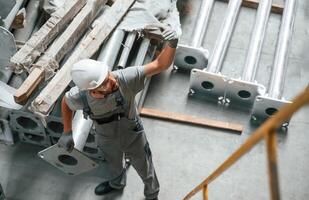 Making ,gesture by hands.. Young factory worker in grey uniform photo