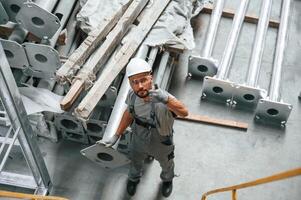 Top ,view... Making gesture by hands. Young factory worker in grey uniform photo
