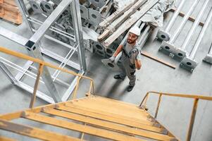 Climbing ,up on the ladder. Young factory worker in grey uniform photo